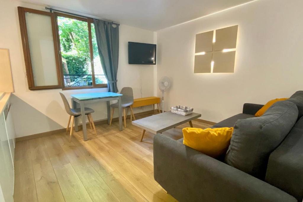 un salon avec un canapé et une table dans l'établissement Beautiful appartment in the Vieille Ville d'Annecy at 200m from the lake, à Annecy