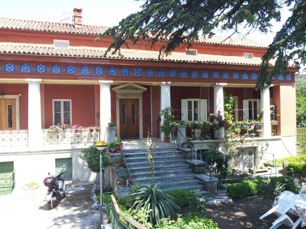 Una casa vieja con escaleras delante. en Casa Vacanze Villa Pompeiana, en Trieste
