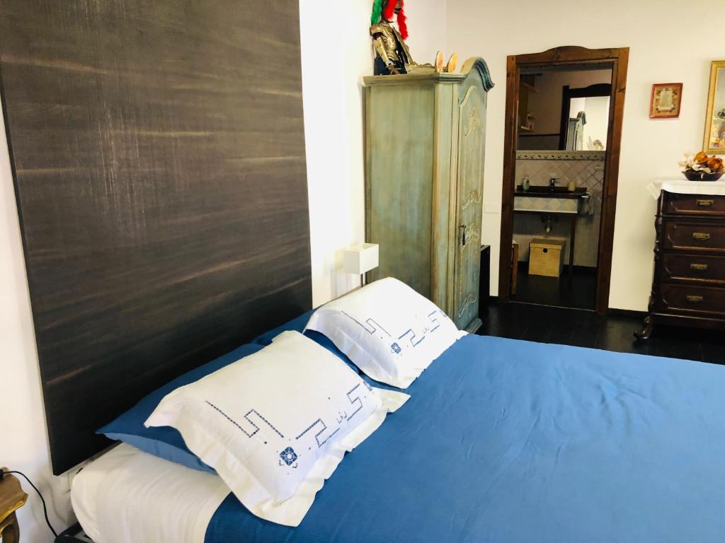 - une chambre avec un lit bleu et 2 oreillers blancs dans l'établissement Il Granaio - luxury private double room, à Monserrato