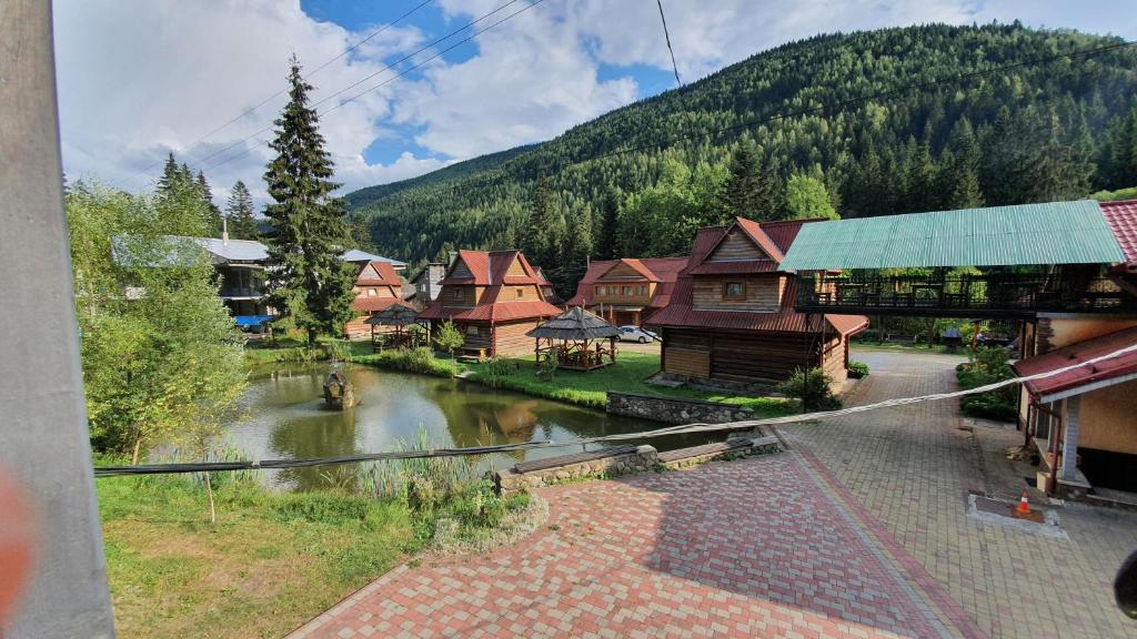 a view of a village with a river and houses at Smerekova Hata in Yablunytsya