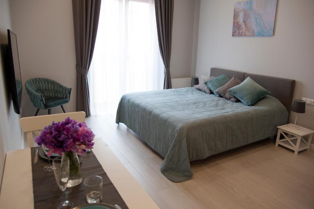 - une chambre avec un lit et une table fleurie dans l'établissement Kungu Apartments in Riga Old Town, à Riga