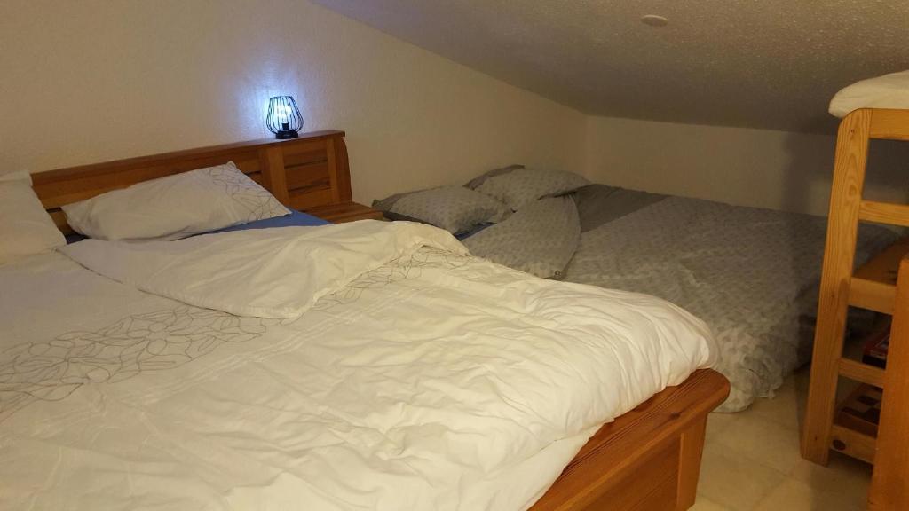 a bedroom with two beds and a light on the wall at Tignes 1800 in Tignes