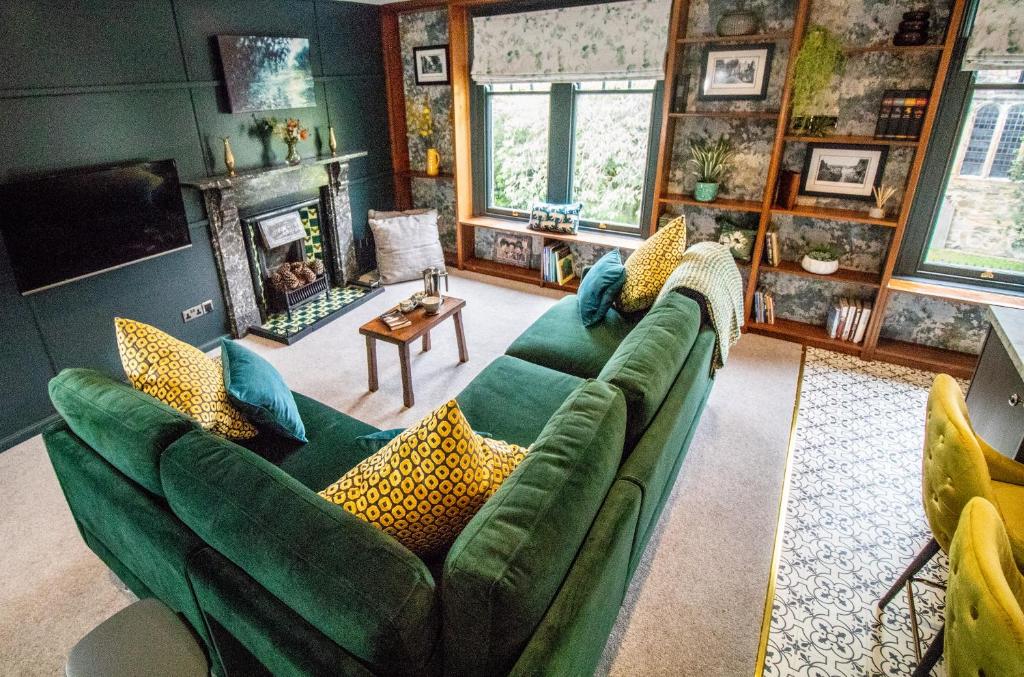 a living room with a green couch and a fireplace at Wuthering Heights in Sedbergh