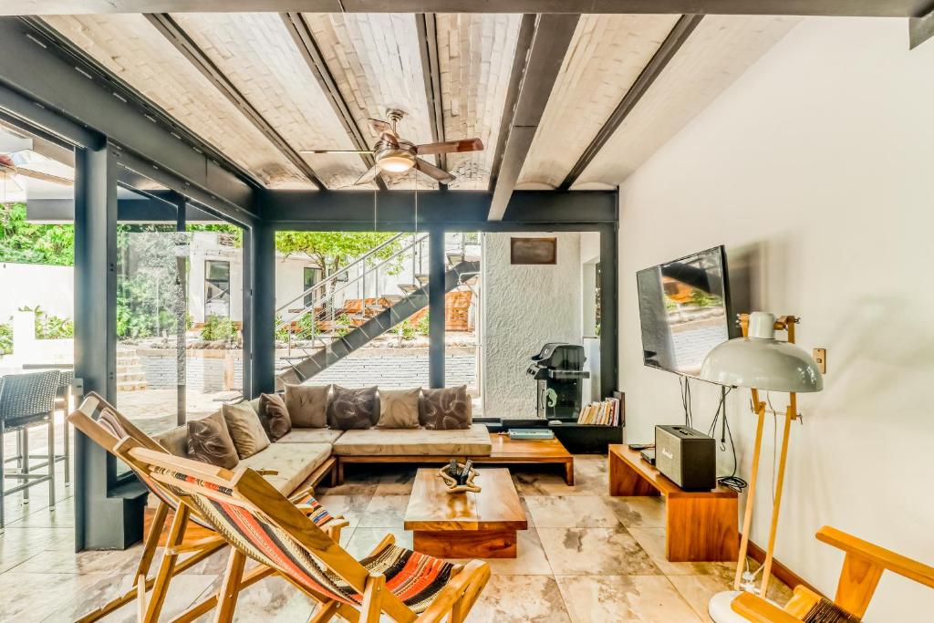 a living room with a couch and chairs at Casa Guarumo Carrillo in Carrillo