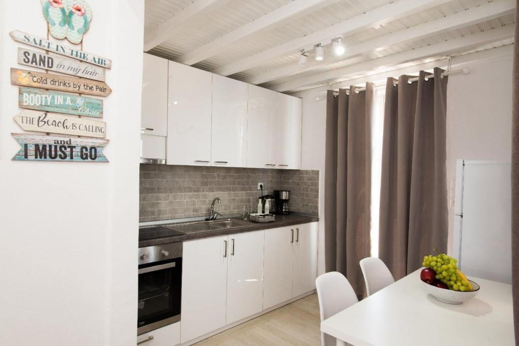 kuchnia z białymi szafkami i białym stołem w obiekcie CASA DI MYKONOS w mieście Mykonos