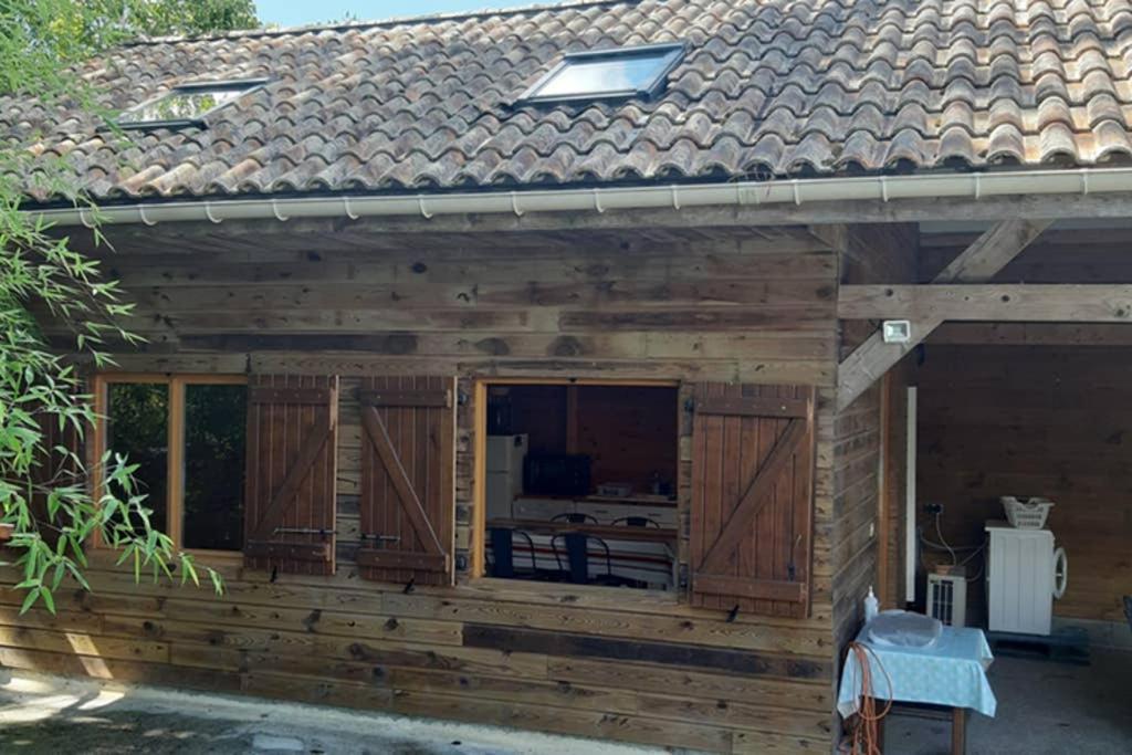 a large wooden house with a large window at la cabane au fond du jardin in Arsac