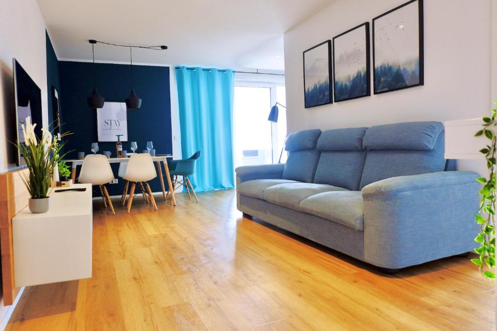 a living room with a blue couch and a table at Boutique Appartement @Park in Rheinhausen