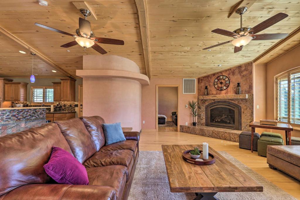 a living room with a leather couch and a fireplace at Prescott Home Less Than 5 Miles to Butte Creek Trail! in Prescott
