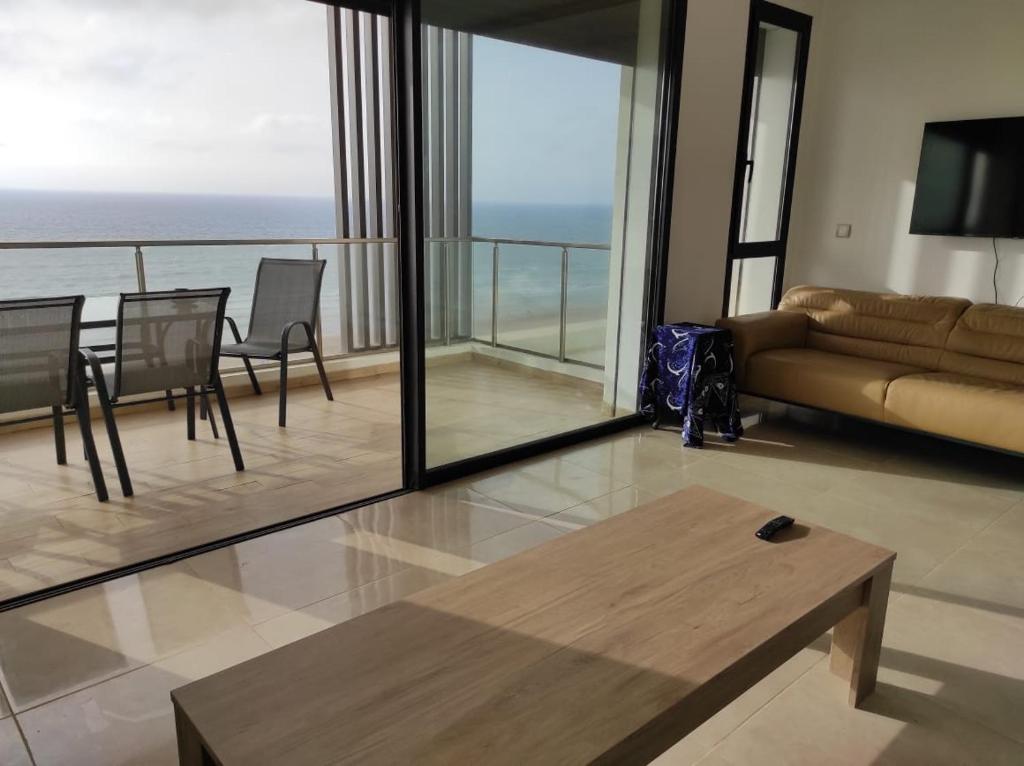 sala de estar con sofá y mesa en Bel appartement à plage des Nation en Salé