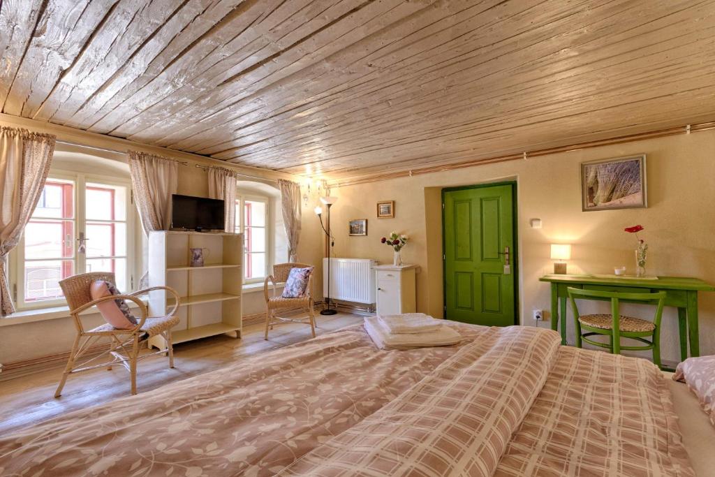 1 dormitorio con 1 cama grande y techo de madera en Měšťanský dům - kulturní památka Mlýnská 119, en Jindřichův Hradec