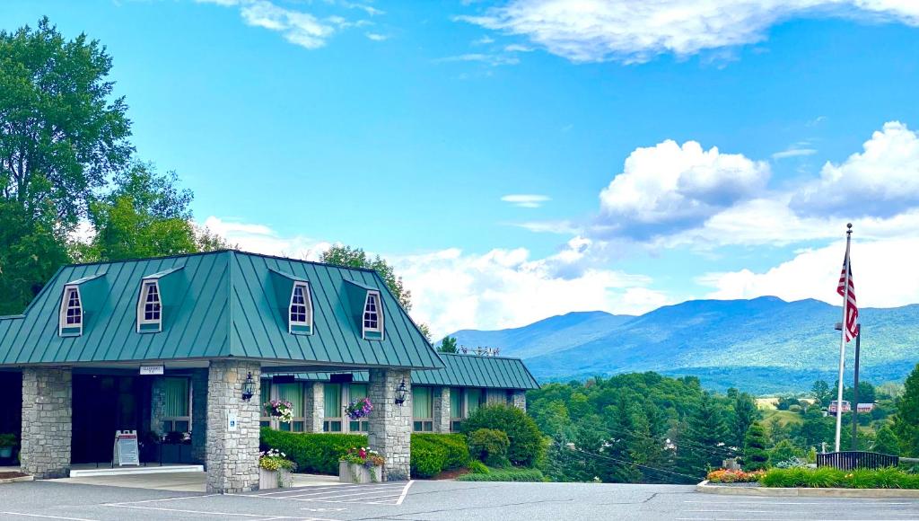 een gebouw met een groen dak met een vlag bij Best Western Plus Waterbury - Stowe in Waterbury