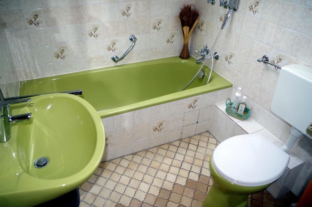 uma casa de banho com uma banheira verde e um WC. em Ferienwohnung Taunus im Grünen Obergeschoss em Langgöns