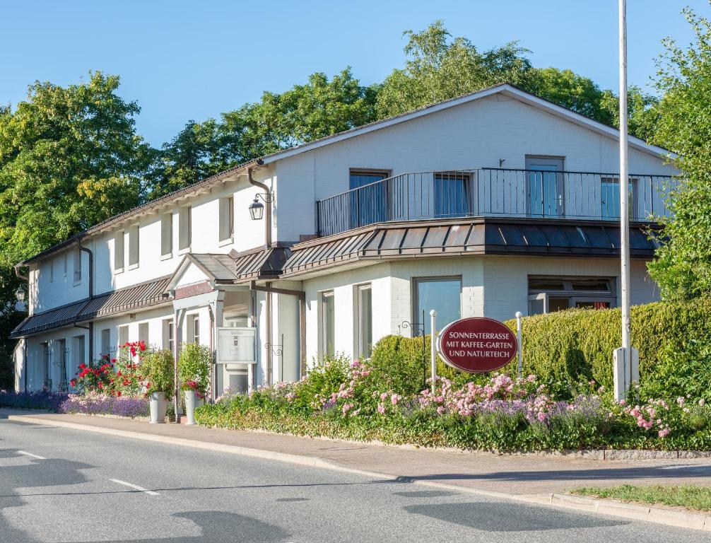 una casa blanca con un cartel delante en Landhaus Schulze-Hamann - Hotel garni - en Blunk