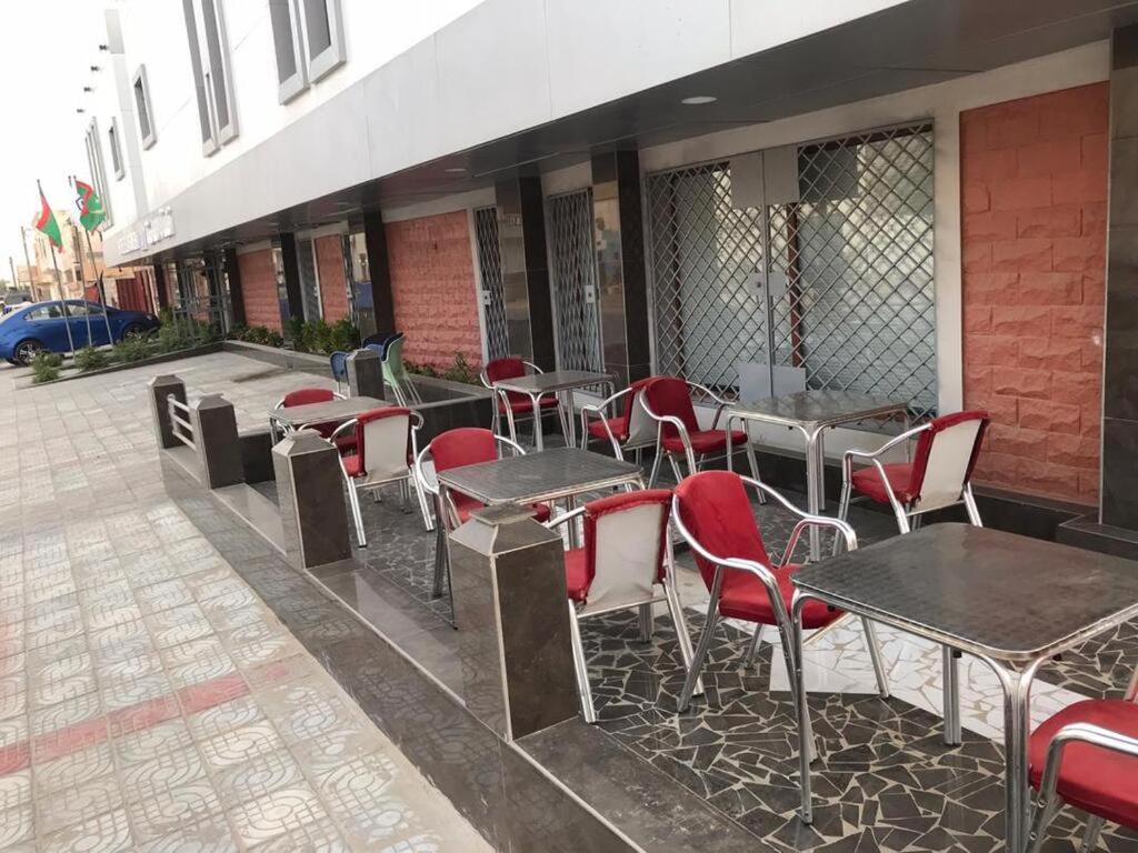 uma fila de mesas e cadeiras fora de um edifício em City Hôtel - Mauritanie em Nouakchott