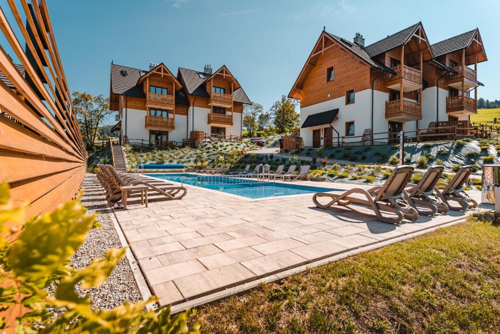 a house with a swimming pool and chairs in the yard at Czeremcha - Ostoja Bukowinki in Jaworki