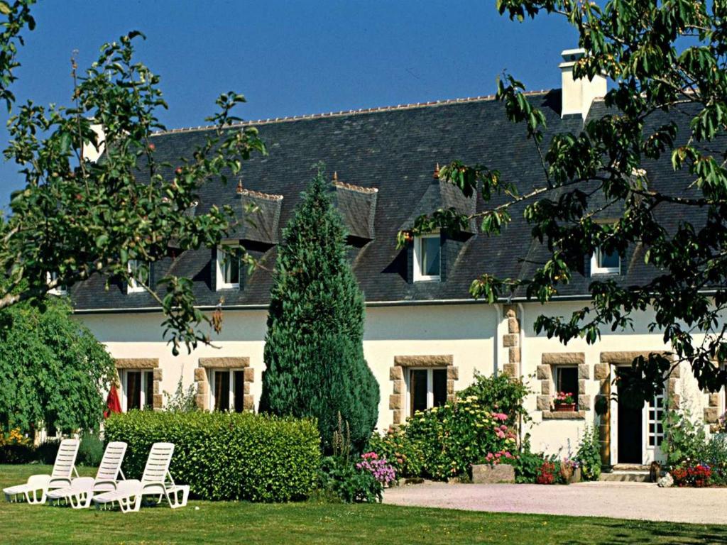 a group of white chairs in front of a house at Domaine De Kereven in Bénodet