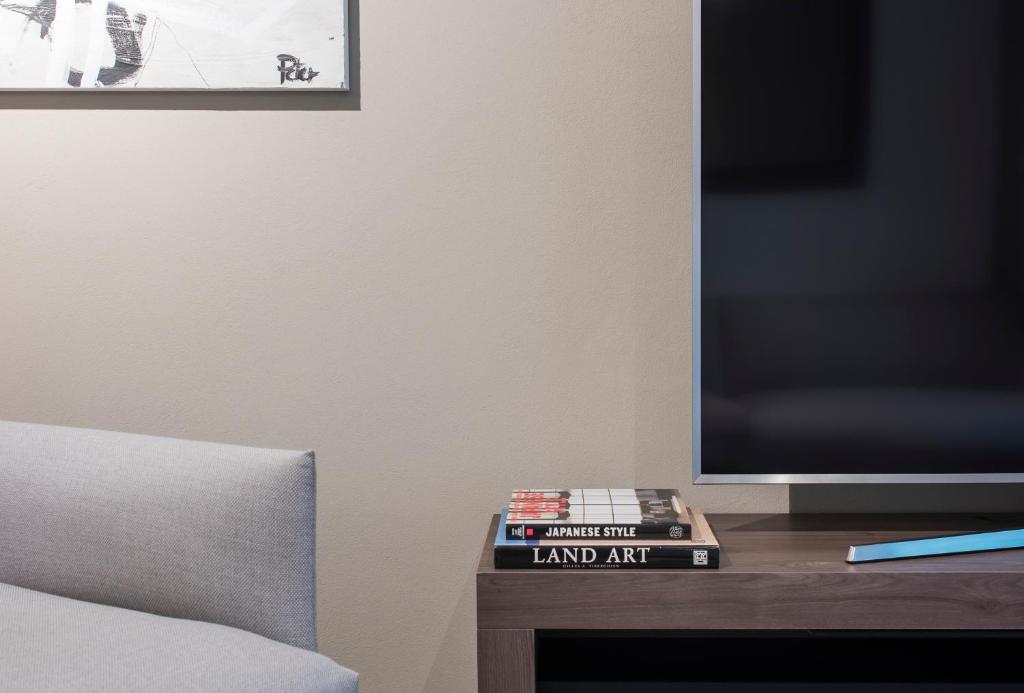 a stack of books sitting on a table next to a television at Résidence hôtelière La Paudèze in Paudex