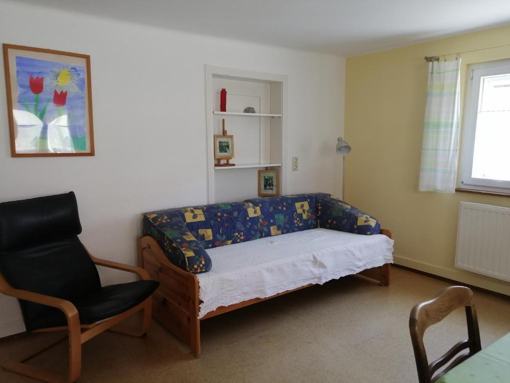 1 dormitorio pequeño con 1 cama y 1 silla en Apartment & Zimmer Familie Trescher, en Tübingen