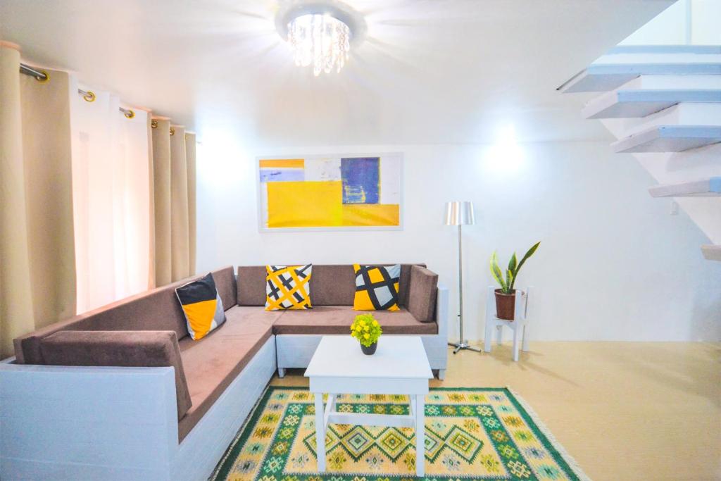 - un salon avec un canapé et une table dans l'établissement Charming Modern 2-Bedroom Apartment, Olongapo City Center, à Olongapo
