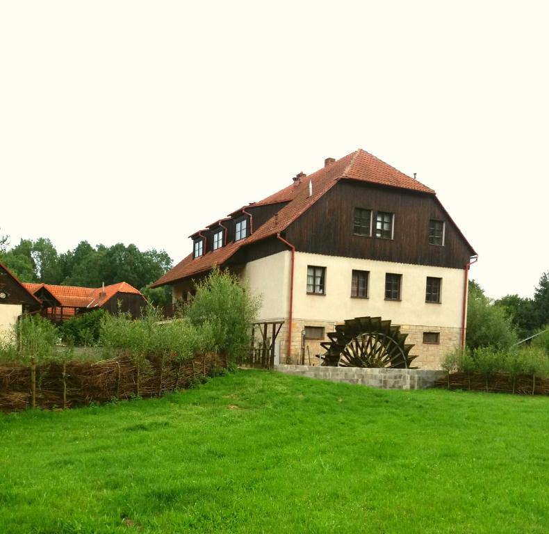 a large white house with a wooden roof at Kratochviluv mlyn in Červená Lhota