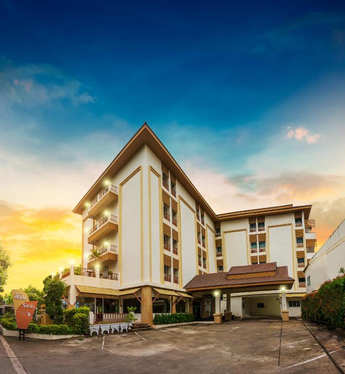 a large white building with a parking lot at Sirin Hotel & Resident in Khon Kaen