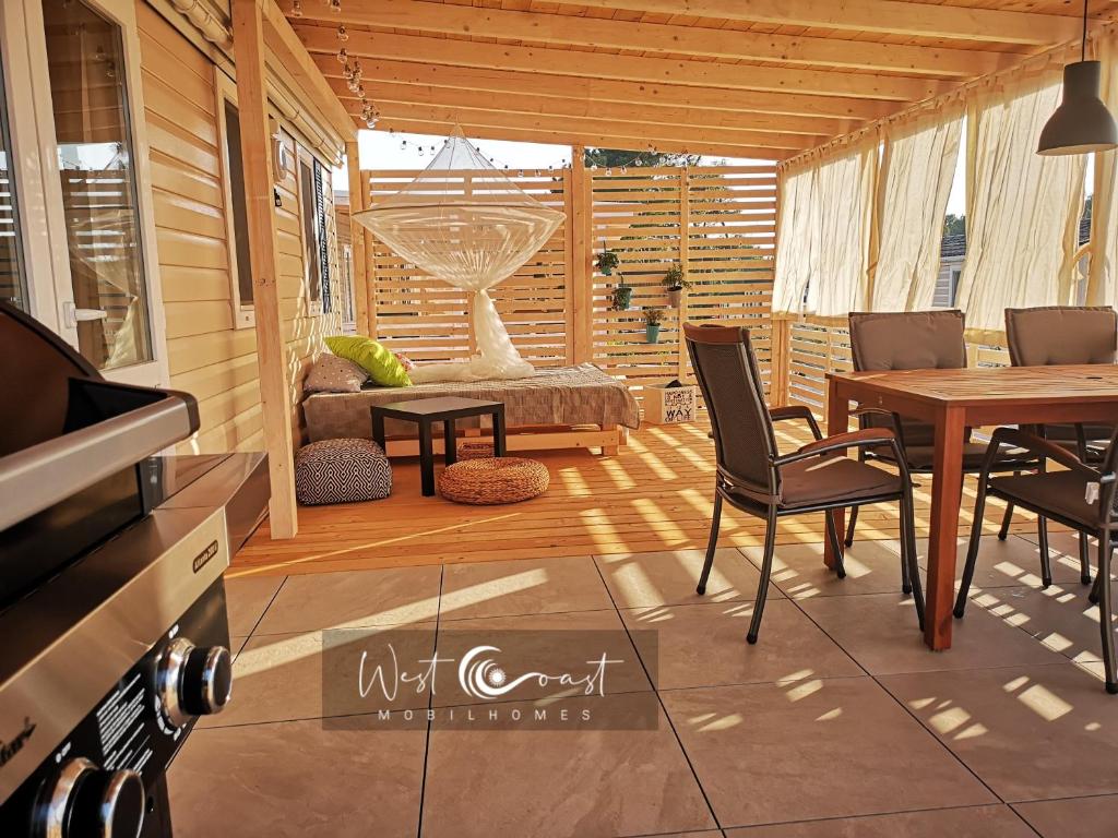 a screened in porch with a table and chairs at West Coast Mobilhome with XXL Terrace in Poreč