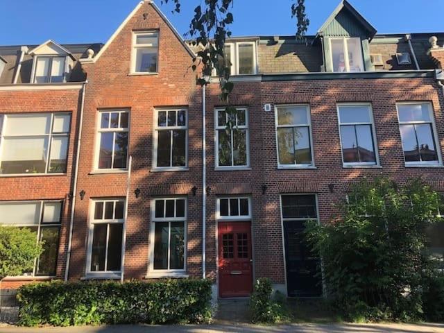 um edifício de tijolos vermelhos com uma porta vermelha em modern genieten in oud binnenstadspand em Amersfoort