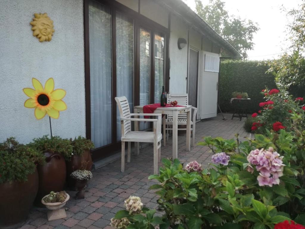 a patio with a table and chairs and flowers at De Zon B&B in Heist-op-den-Berg