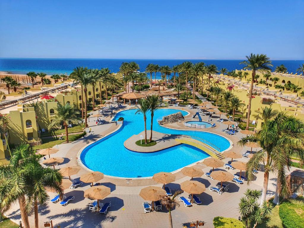 einen Luftblick auf einen Pool mit Sonnenschirmen des Resorts in der Unterkunft Palm Beach Resort Families and Couples only in Hurghada