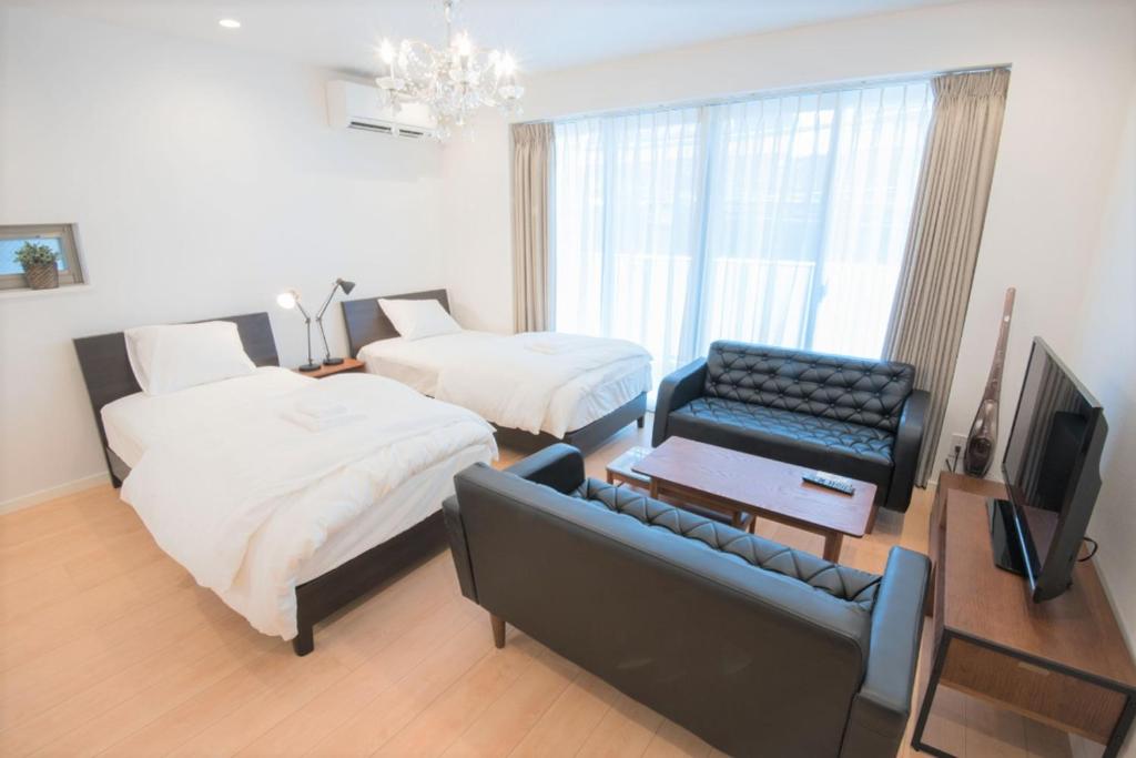 - une chambre avec 2 lits, un canapé et une télévision dans l'établissement Salon Shibuya - Vacation STAY 78187, à Tokyo