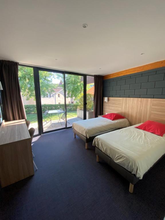 a hotel room with two beds and a large window at Chateau de Collonges in Saint-Donat-sur-lʼHerbasse