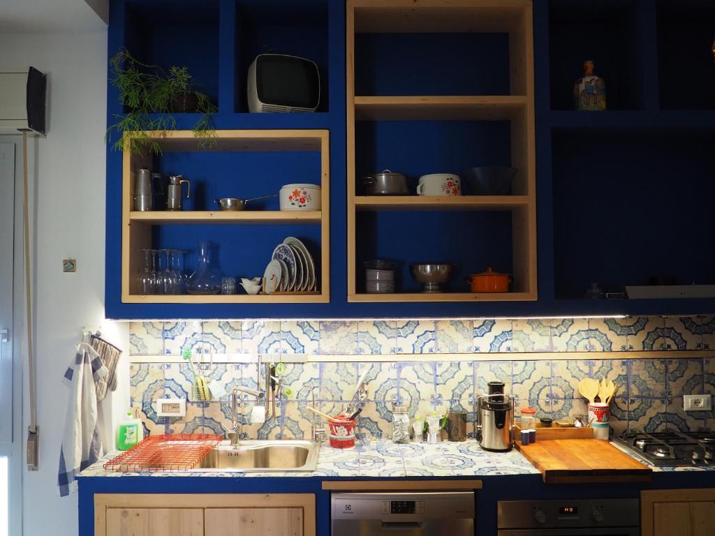 uma cozinha com armários azuis e uma bancada em Silibardi em Agrigento
