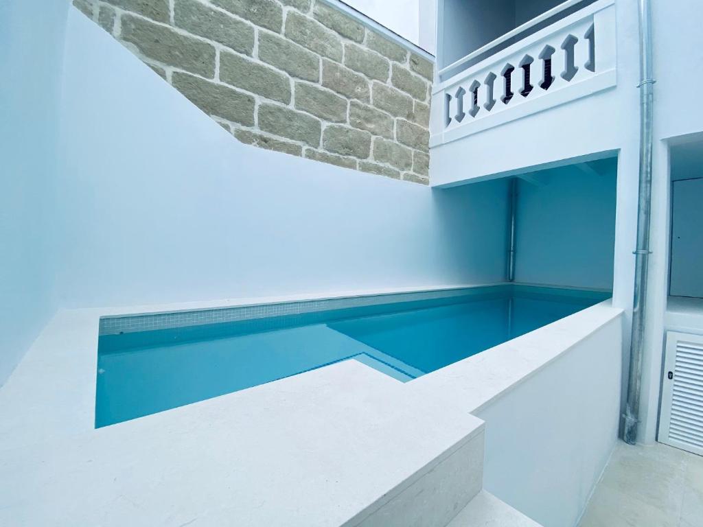 a swimming pool in a house with a brick wall at Hotel Casa Miranda - Adults Only in Mahón