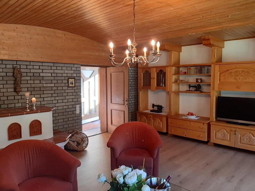 a living room with two chairs and a television at Exklusiv Apartment Sonnenalp in Niederau