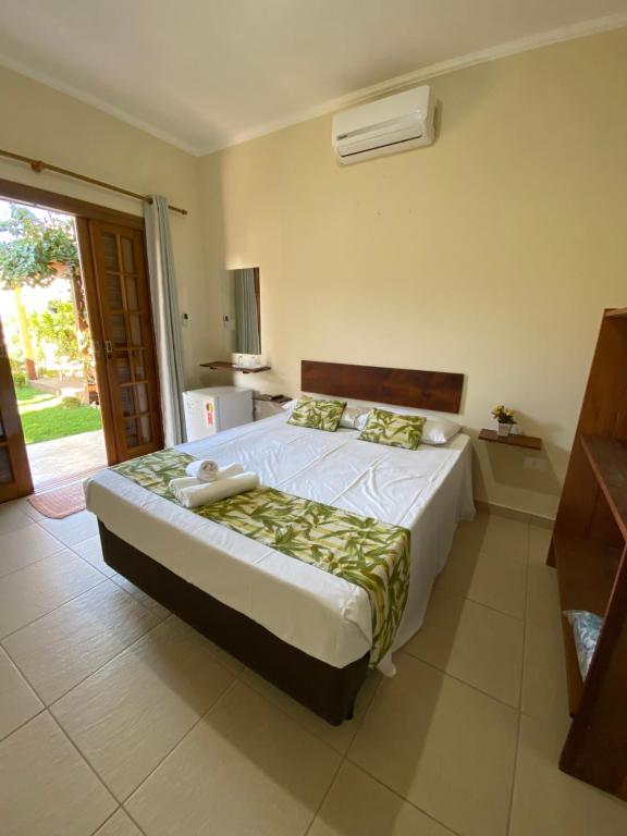 1 dormitorio con 1 cama grande en una habitación en Pousada da Brisa, en Itanhaém