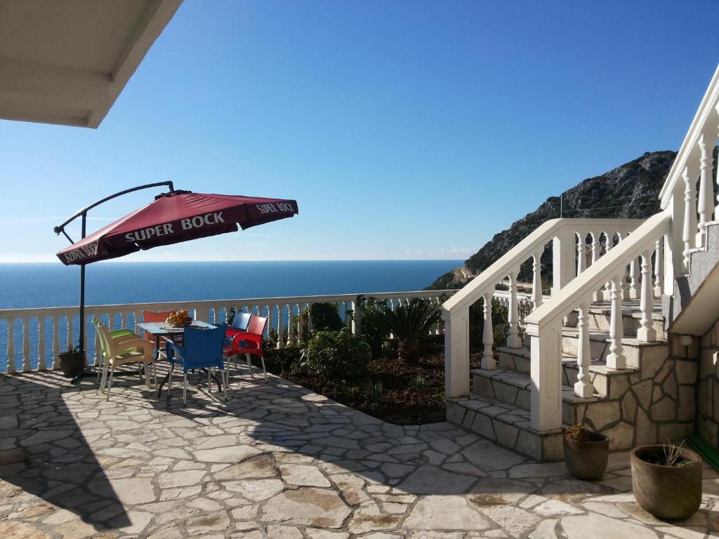 a patio with a table and an umbrella at Apartments Dora in Dobra Voda