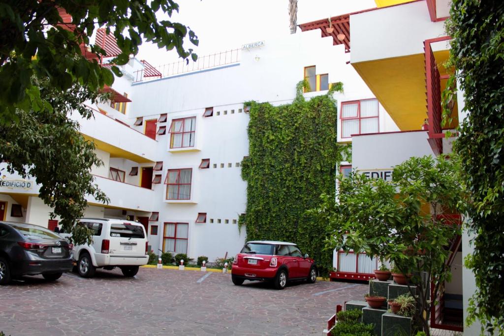 un edificio con coches estacionados frente a él en INMOTEGA - Suites TG, en San Luis Potosí
