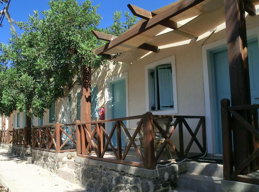 una valla de madera frente a una casa en Santorini Camping/Rooms, en Fira