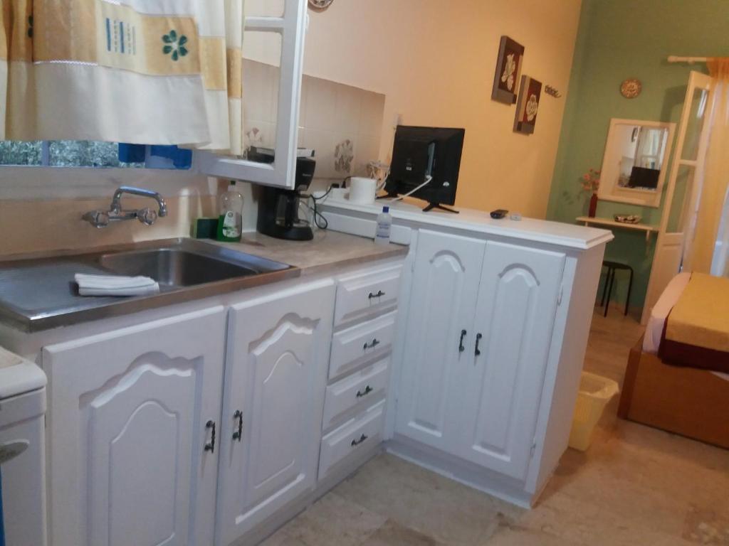 a kitchen with white cabinets and a sink at Irene's studios in Panormos Kalymnos