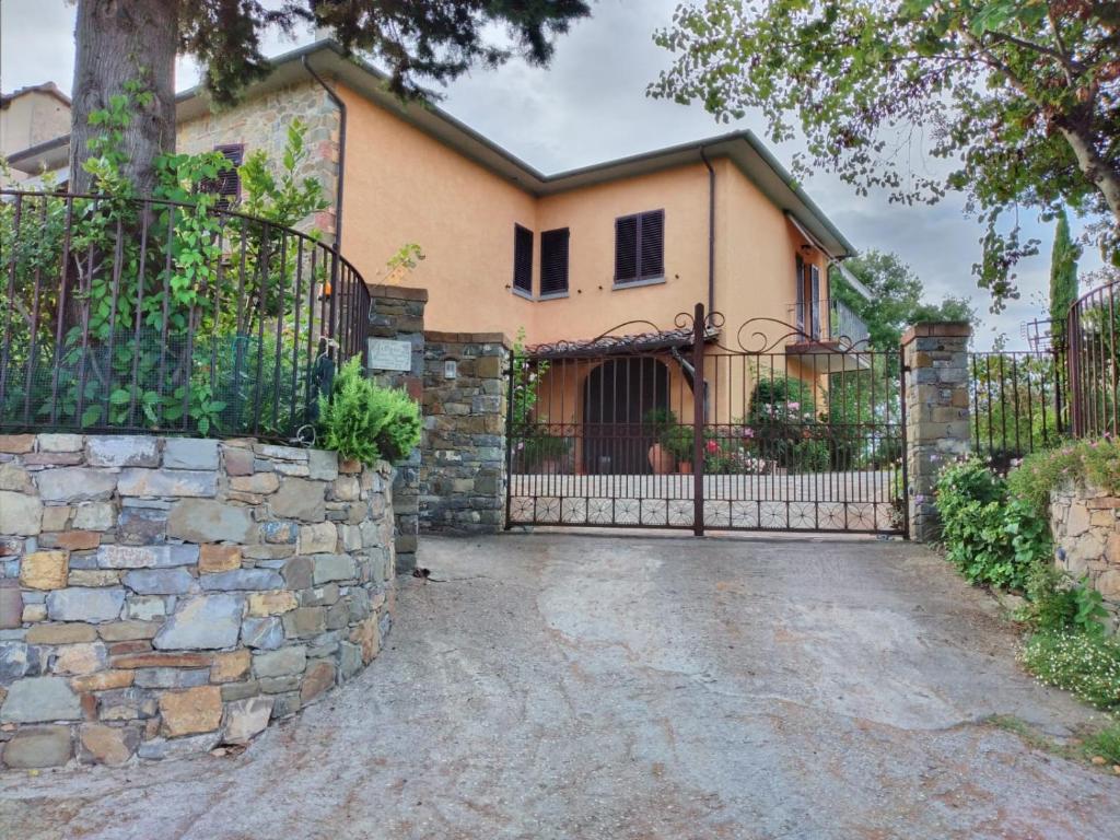 ein Haus mit einem Tor und einer Steinmauer in der Unterkunft B&B L'Oliveto in Lucignano