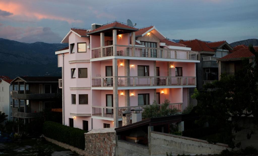 Un grand bâtiment blanc avec des lumières sur lui dans l'établissement Apartments Cetina, à Split
