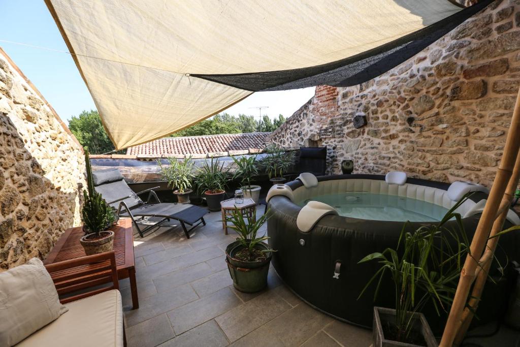 Saint-MacaireにあるMaison atypique dans cité médiévaleの- 植物のあるパティオ(ホットタブ付)