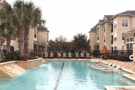 a swimming pool in front of some apartment buildings at Magnificent Furnished Apartment near Exxon Campus in Spring