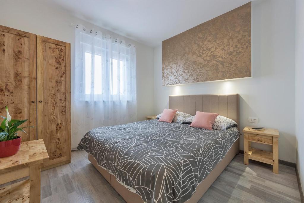 ファジャナにある2 BEDROOM APARTMENT PEROJのベッドルーム1室(ピンクの枕が付いたベッド1台付)