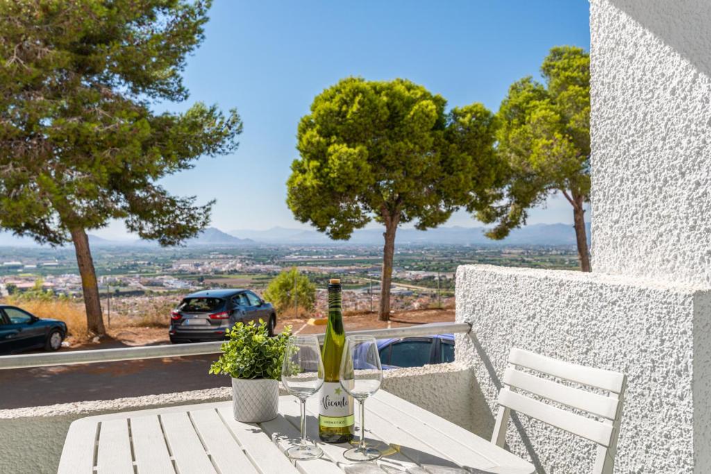 a table with a bottle of wine and two glasses at Apartment with lovely views in Ciudad Quesada in Ciudad Quesada