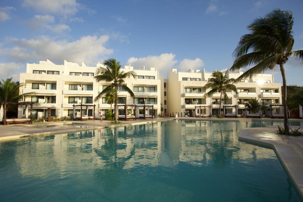 a large swimming pool in front of a building at Akumal Bay Beach & Wellness Resort in Akumal