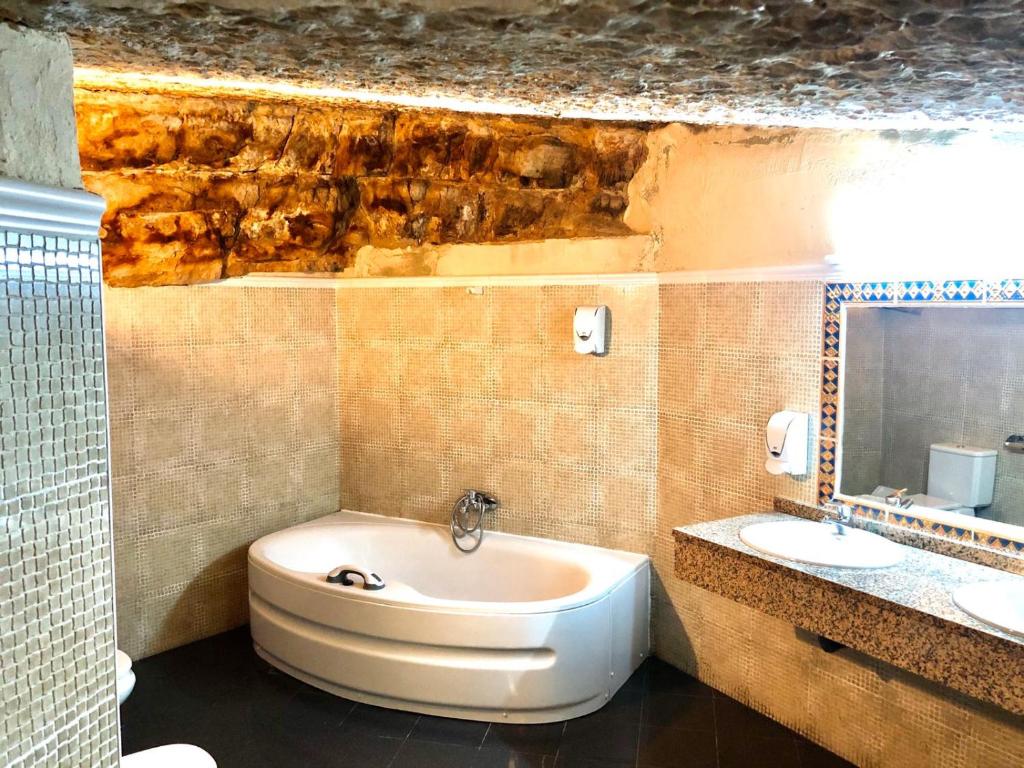 uma casa de banho com um lavatório, um WC e uma banheira em Hostal Posada La Panadera em Sepúlveda