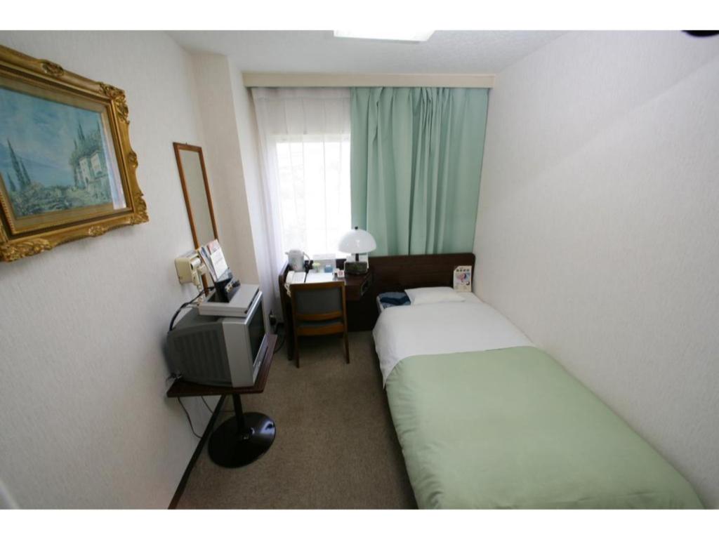 Cette chambre comprend deux lits et une télévision. dans l'établissement Business Hotel Heisei - Vacation STAY 90554, à Yonezawa