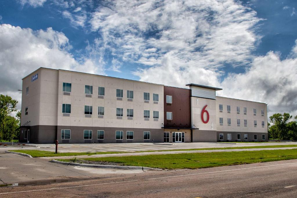 a large white building with a red s on it at Studio 6 North Platte - East in North Platte