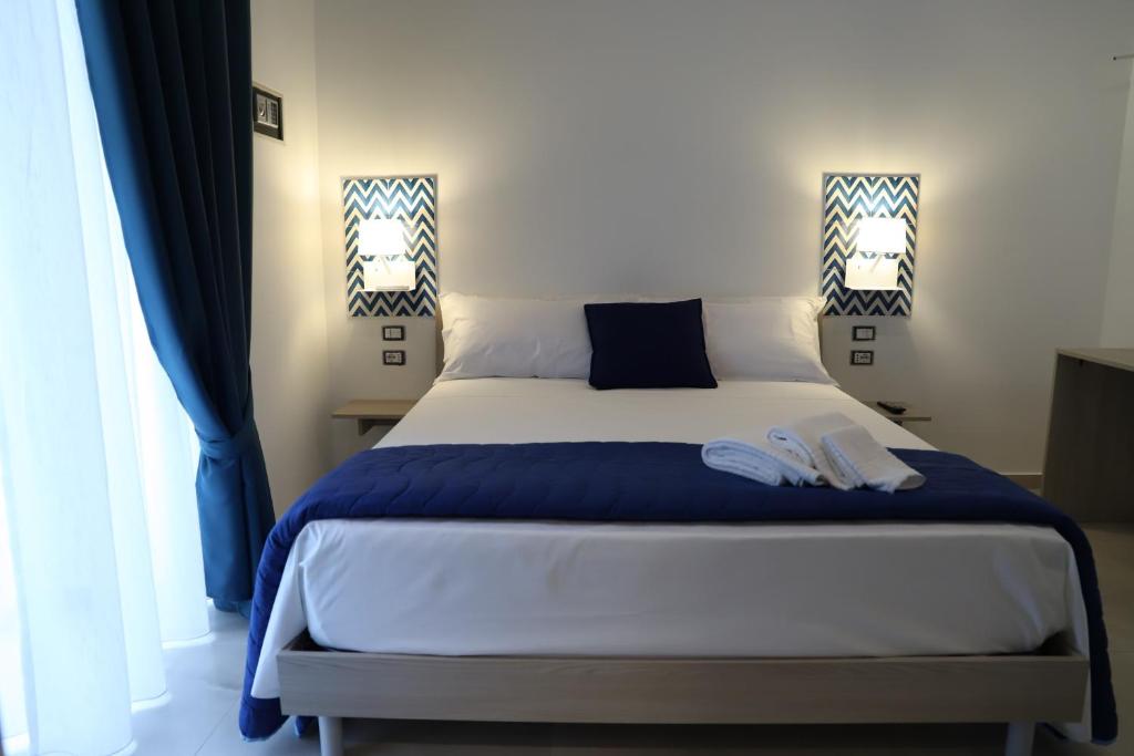um quarto com uma cama com lençóis azuis e brancos em TO DO NAPOLI em Nápoles